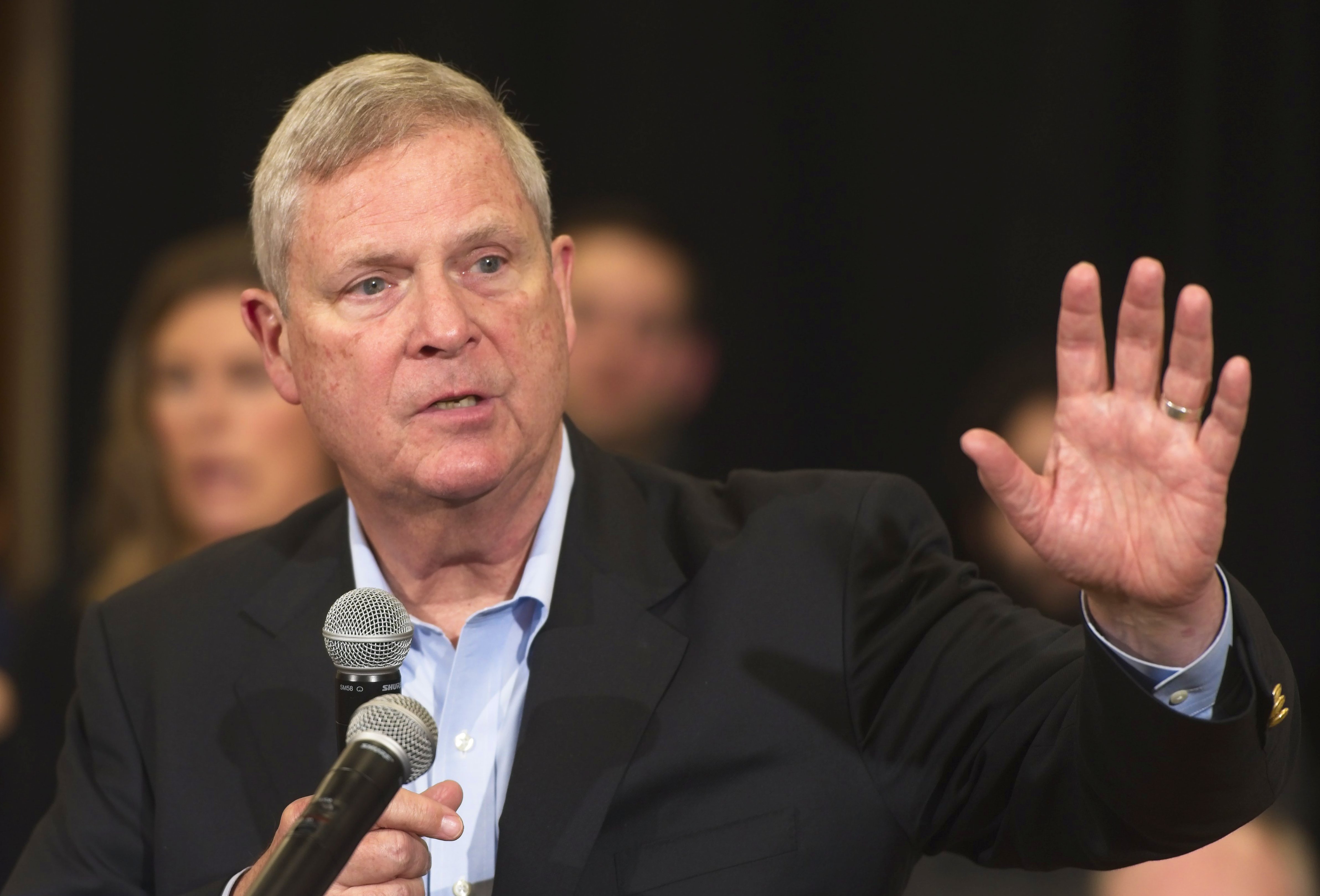 Tom Vilsack speaks into a microphone at a campaign even