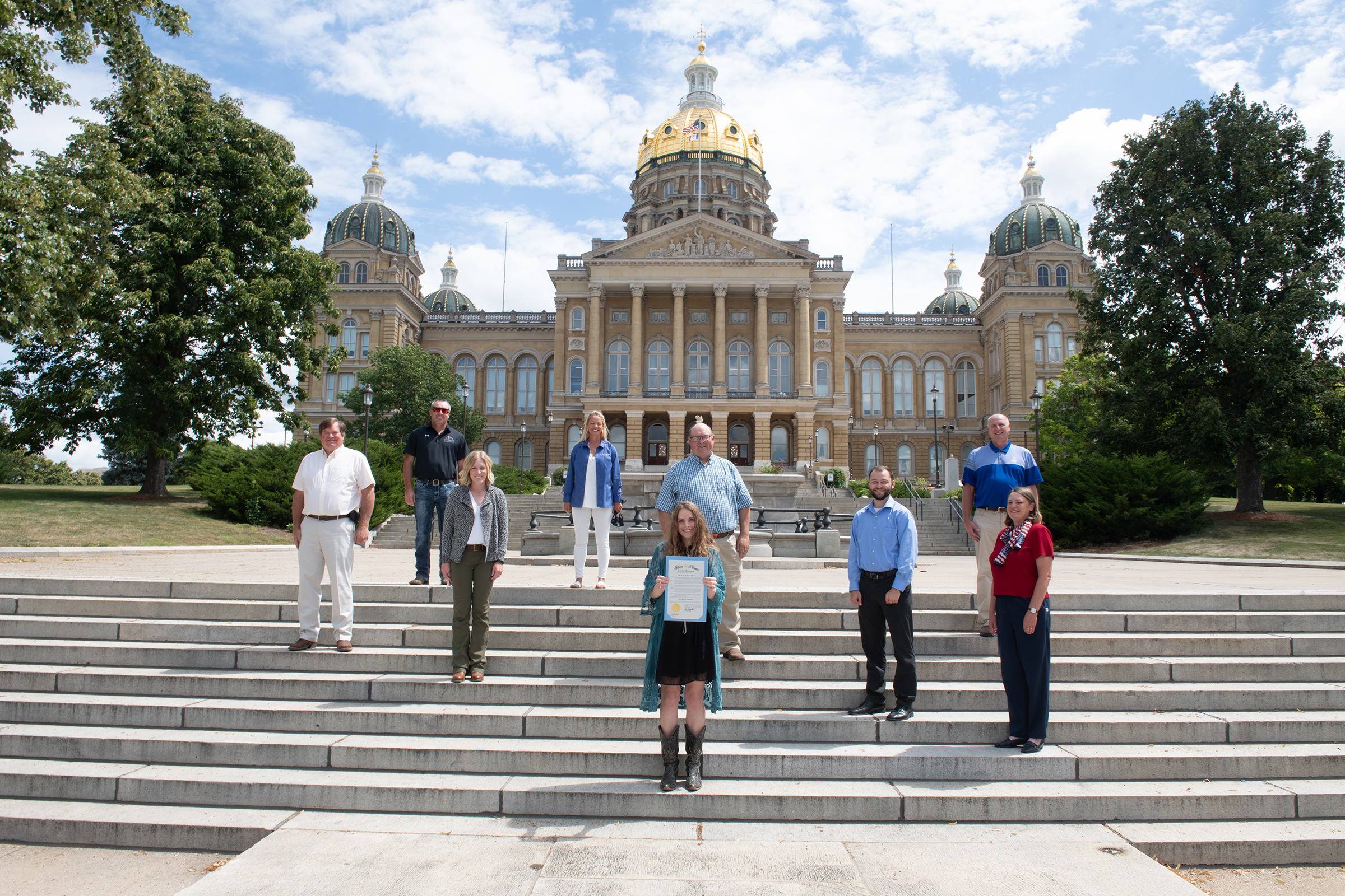 A group of people stand on the steps of the Iowa capito