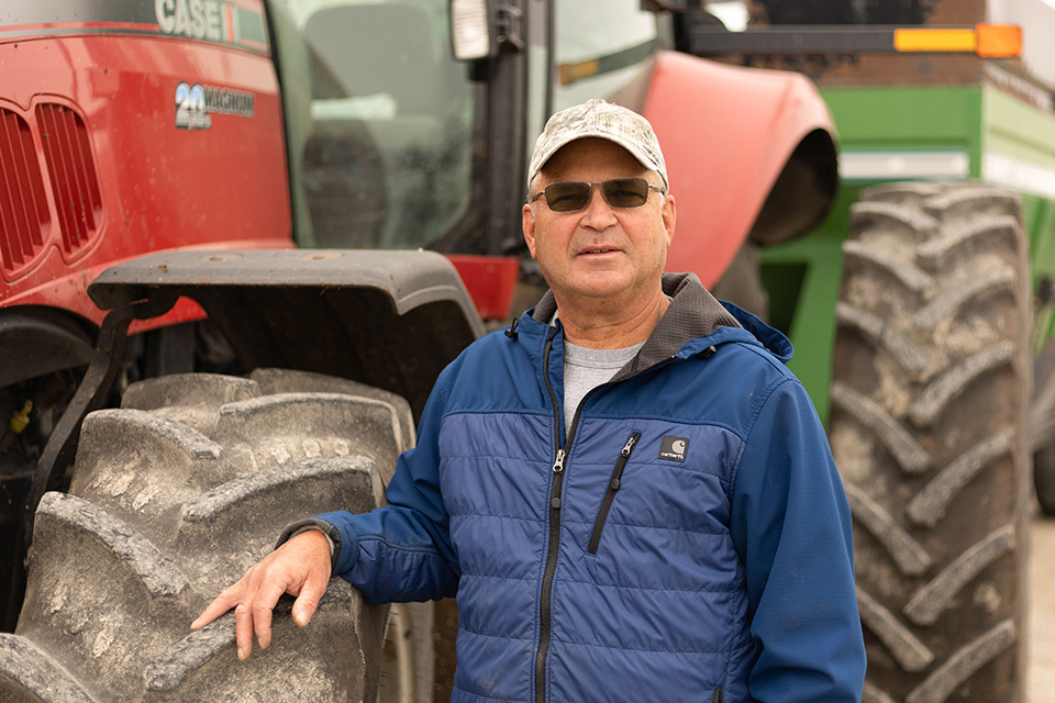 Farmer stands next to tractor