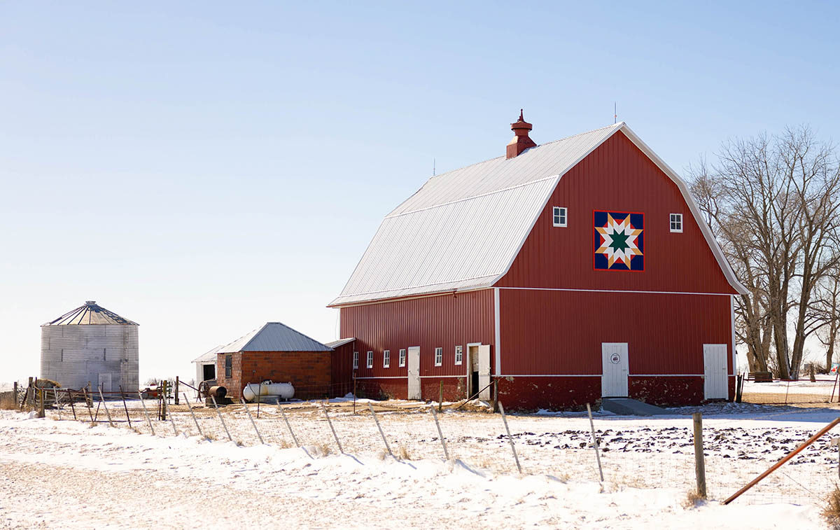 Red barn with barn quilt in the winter