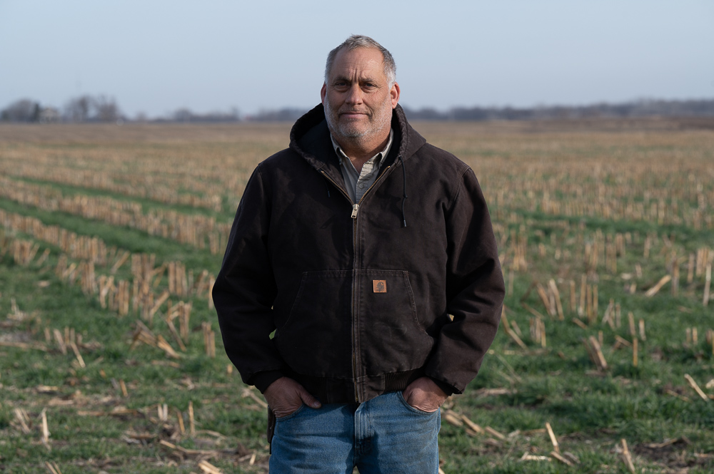 Mark Schleisman stands in a dark jacket on a no-till co