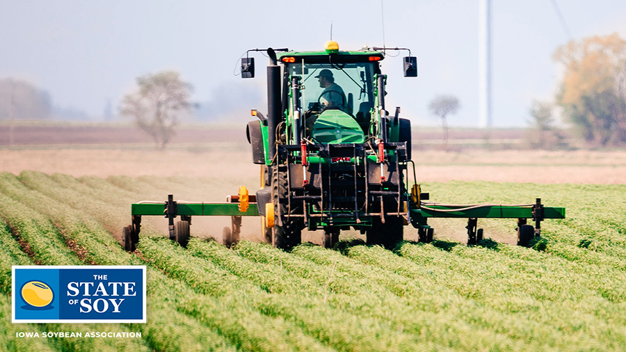 John Deere tractor driving through field