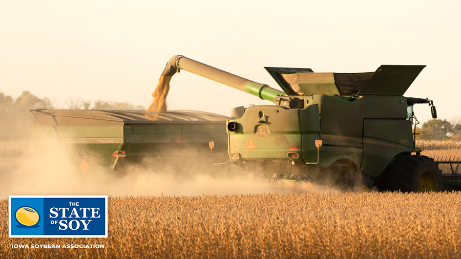John Deere combine filling up grain cart with soybeans