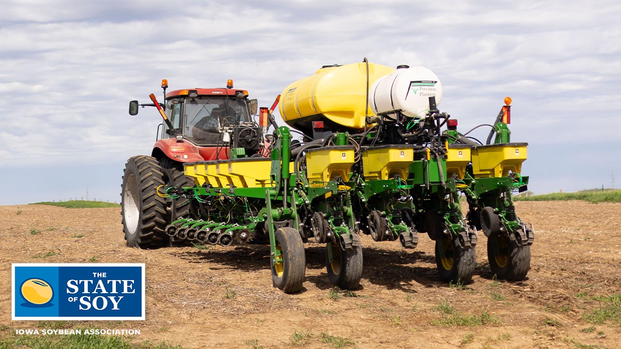 Green planter attached to red tractor