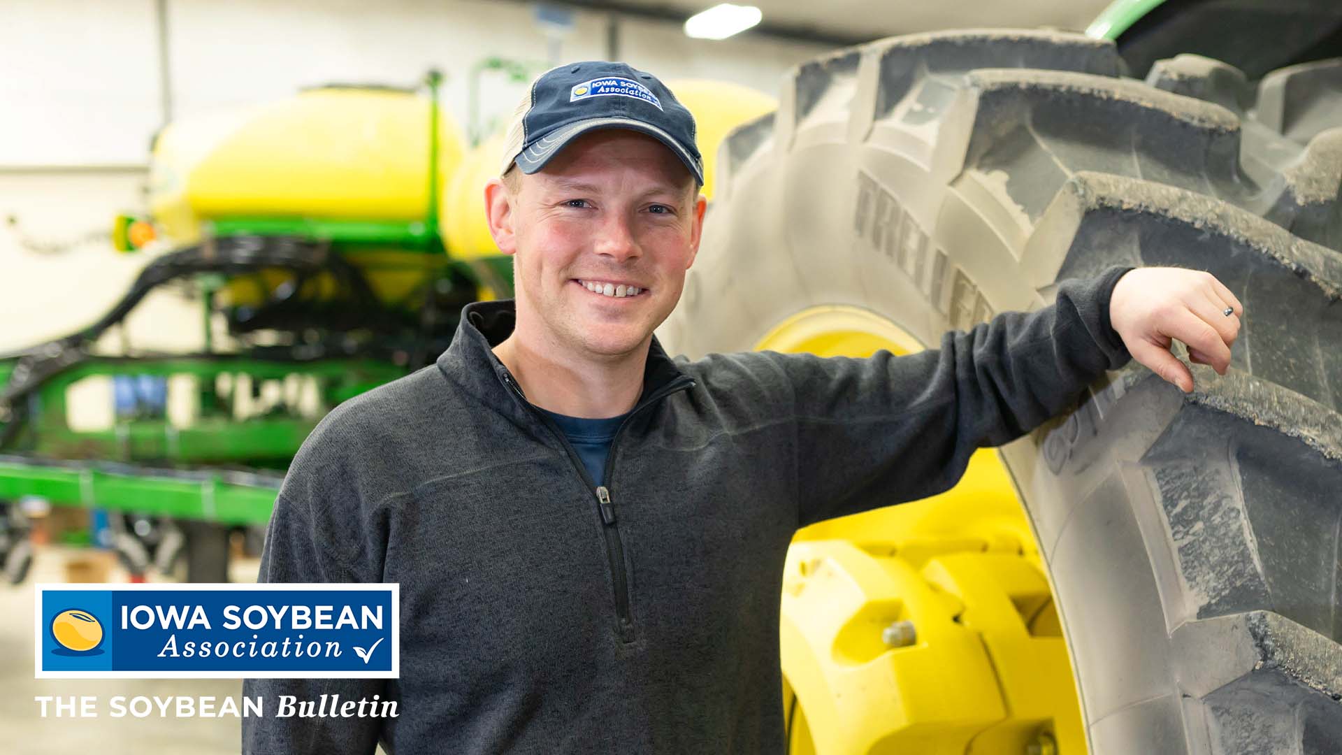 Iowa farmer standing next to John Deere tractor in shed