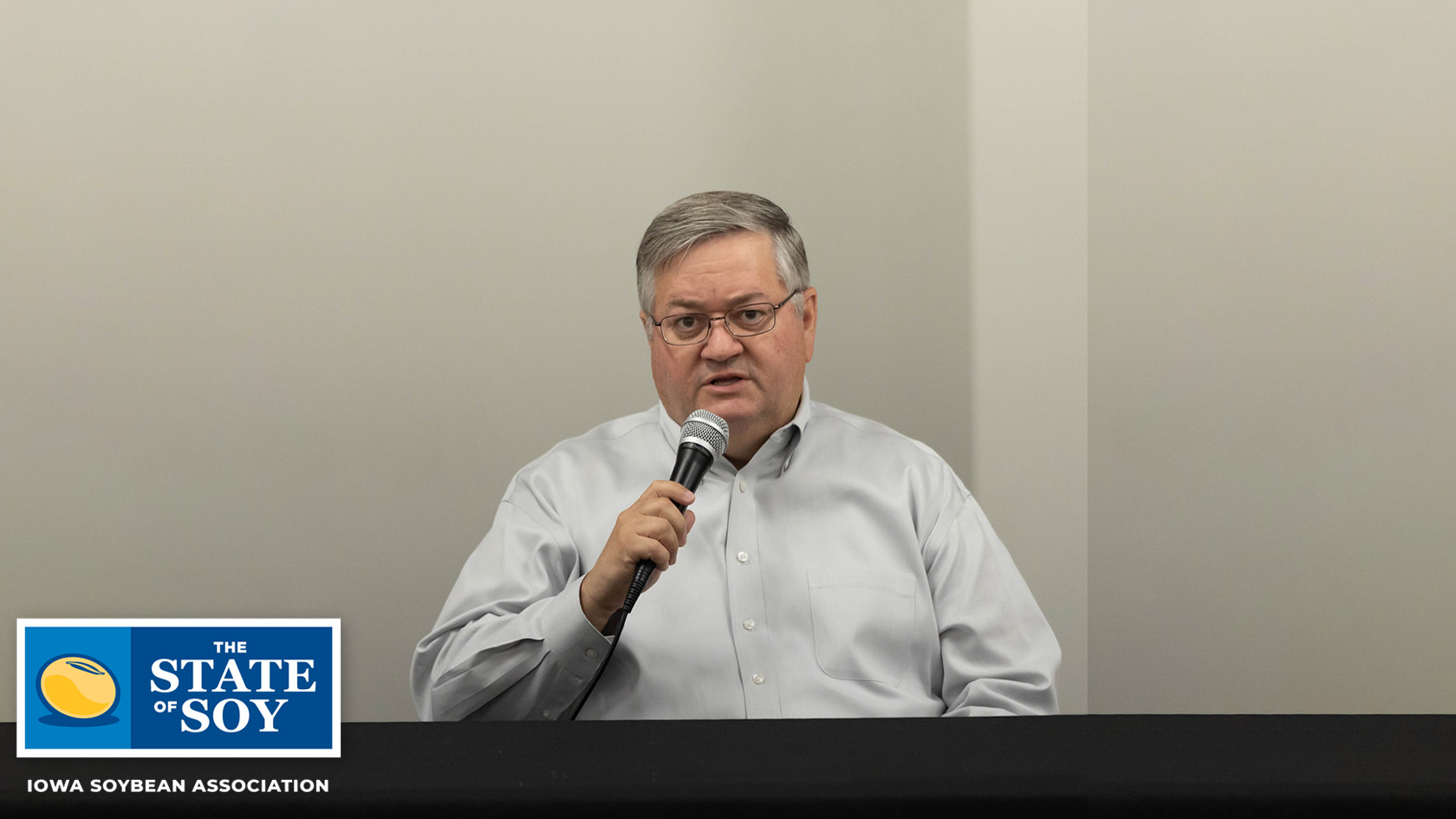 Kirk Leeds speaks into microphone at event