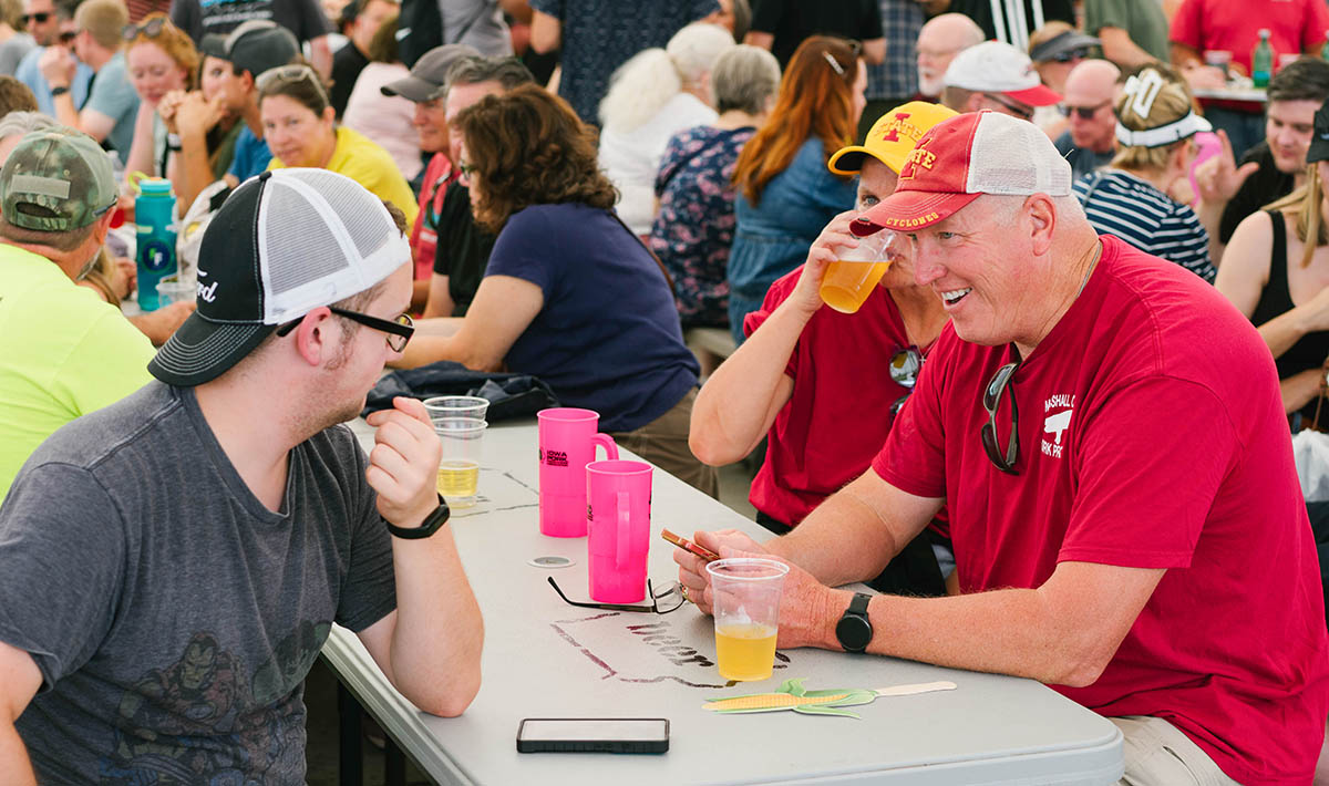 People having drinks at picnic table playing trivia